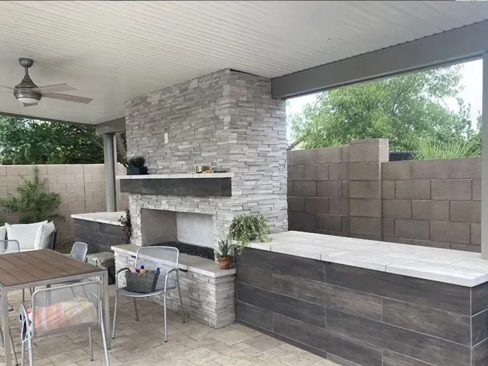 Covered outdoor living space with fireplace by Canterra Construction